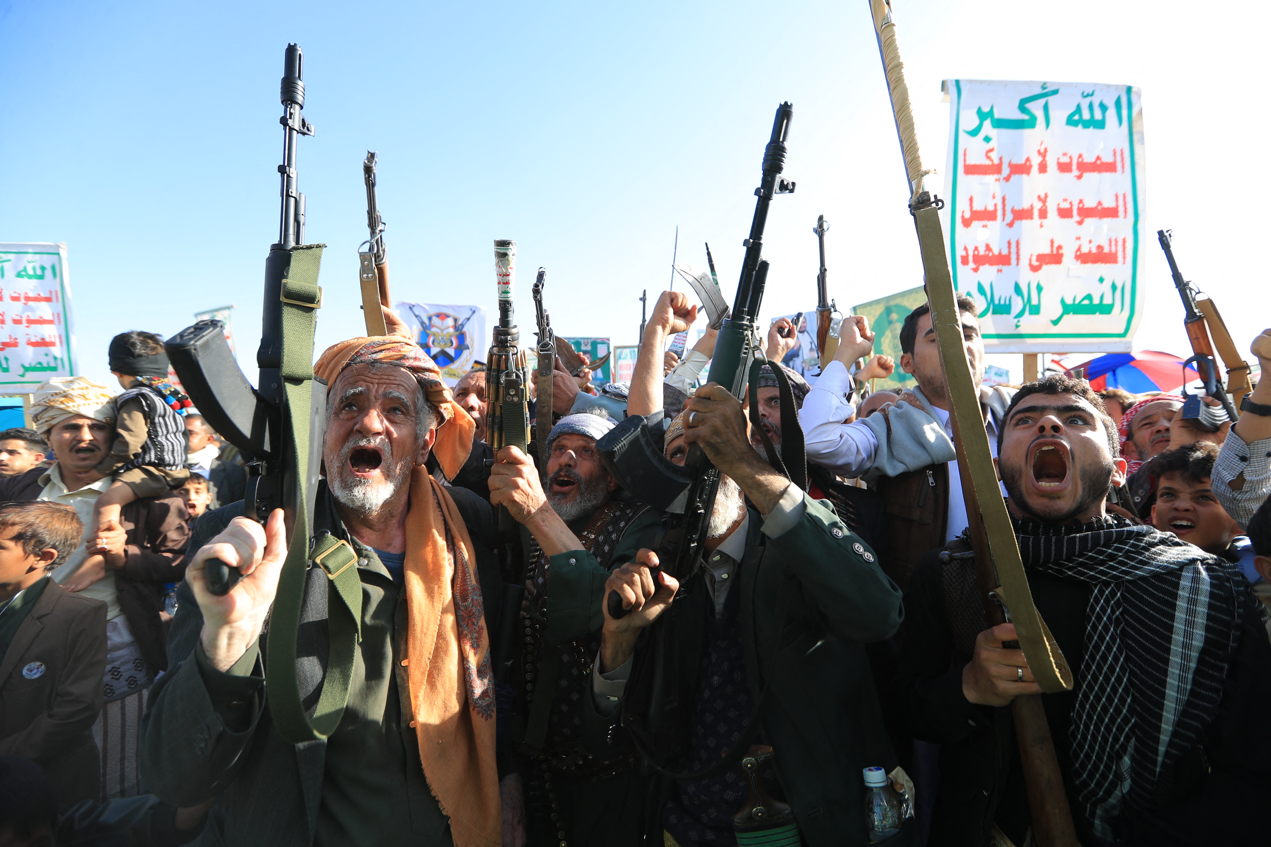 Supporters of the Houthi authorities brandish their weapons during a protest against Saudi intervention in Yemen, in Sanaa, on October 9, 2026.