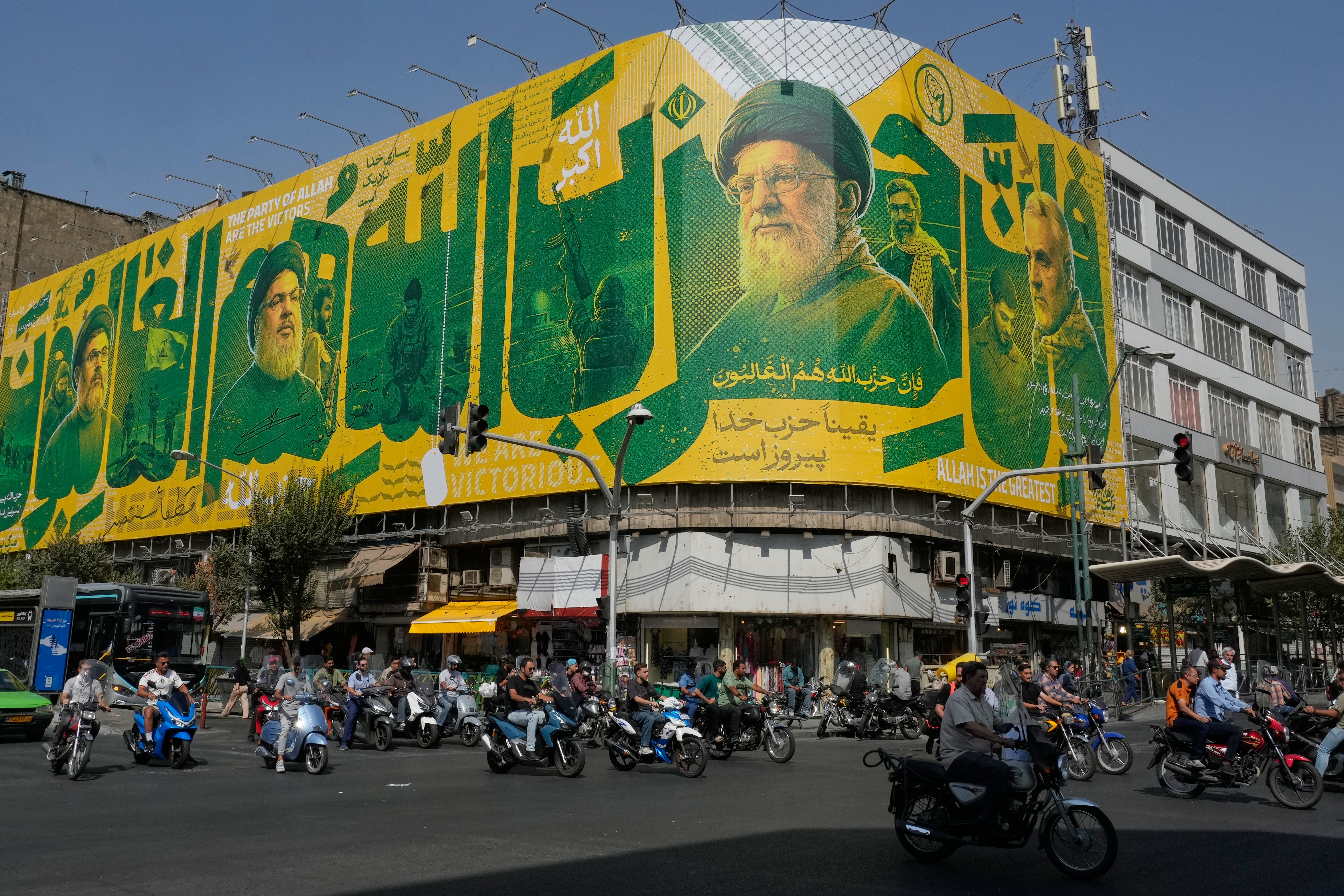 Motorcyclists pass a billboard showing portraits of the late commander of Iran's Revolutionary Guard expeditionary Quds Force, Gen. Qassem Soleimani, right, the late Iranian Supreme Leader Ayatollah Ali Khamenei, center right, late leaders of Lebanon's Hezbollah group Hassan Nasrallah, center left, and Hashem Safieddine, left, marking the second anniversary of the killing of Hassan Nasrallah, in Tehran, Iran, Sunday, Sept. 27, 2026. (AP Photo/Vahid Salemi)