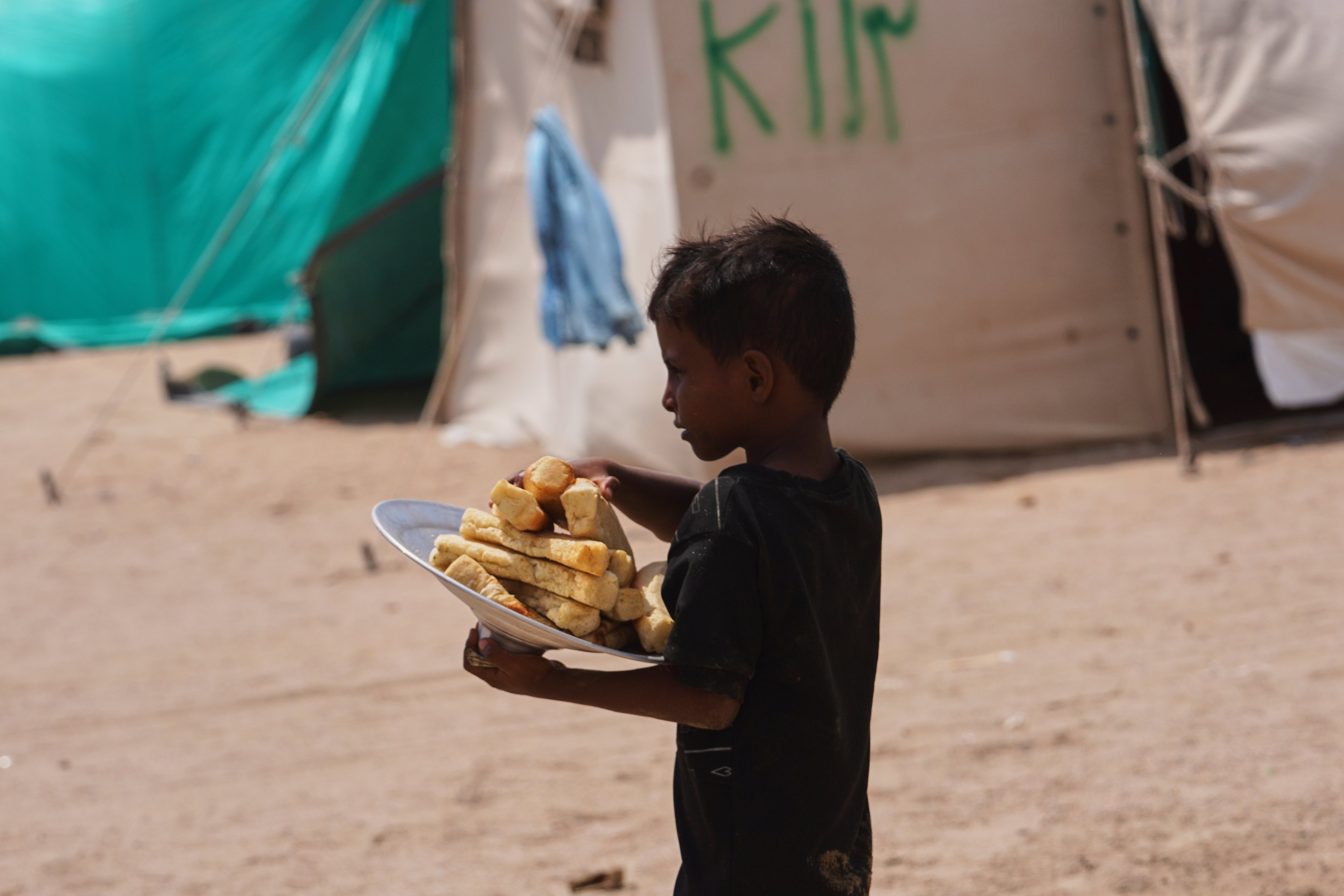 A displaced Yemeni boy carries bread at Al-Firdaws camp in Ras Imran, on the western outskirts of Aden, Yemen, Tuesday, Sept. 29, 2026. (AP Photo/Abdulnasser Alseddik)