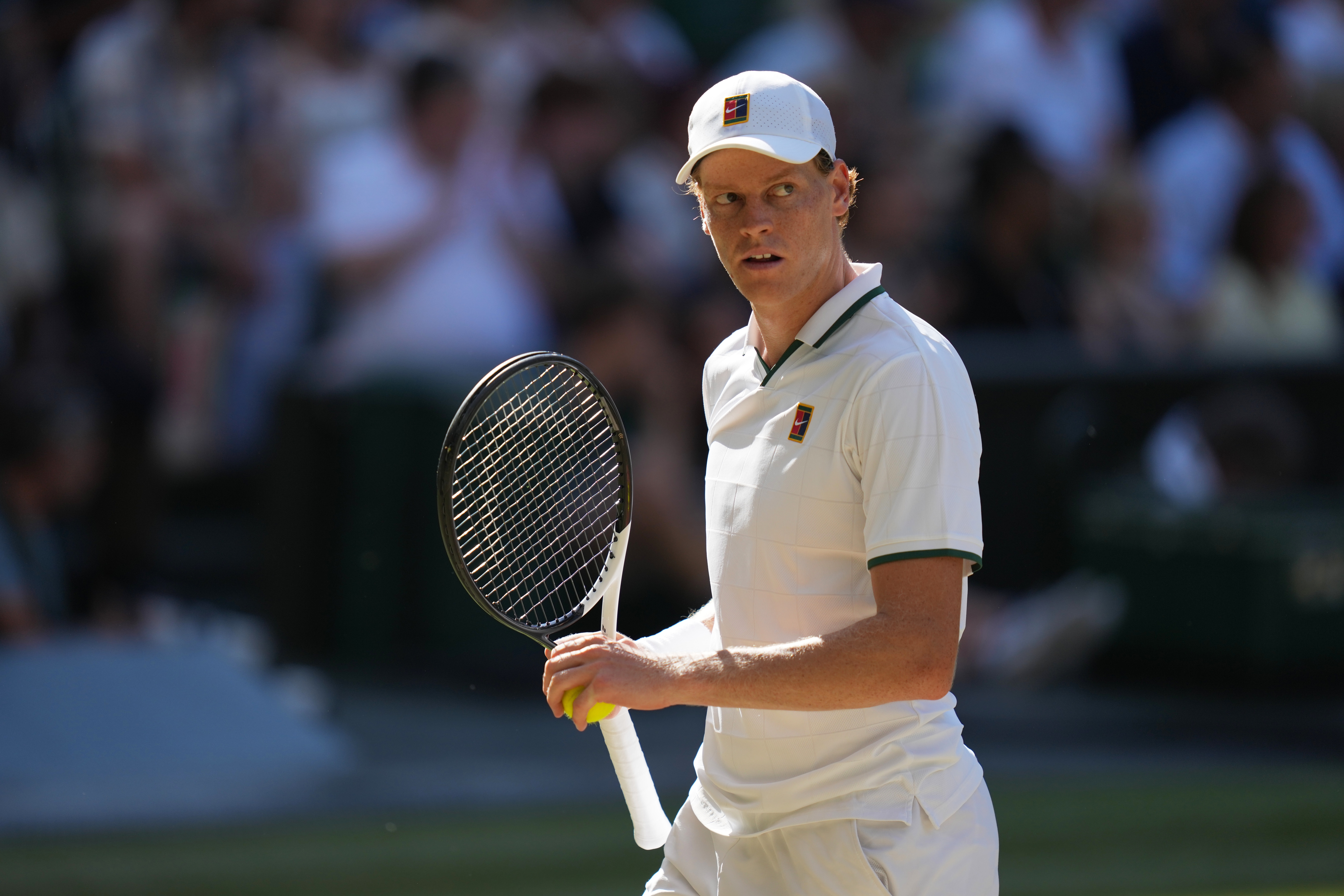 Jannik Sinner holds his tennis racket.