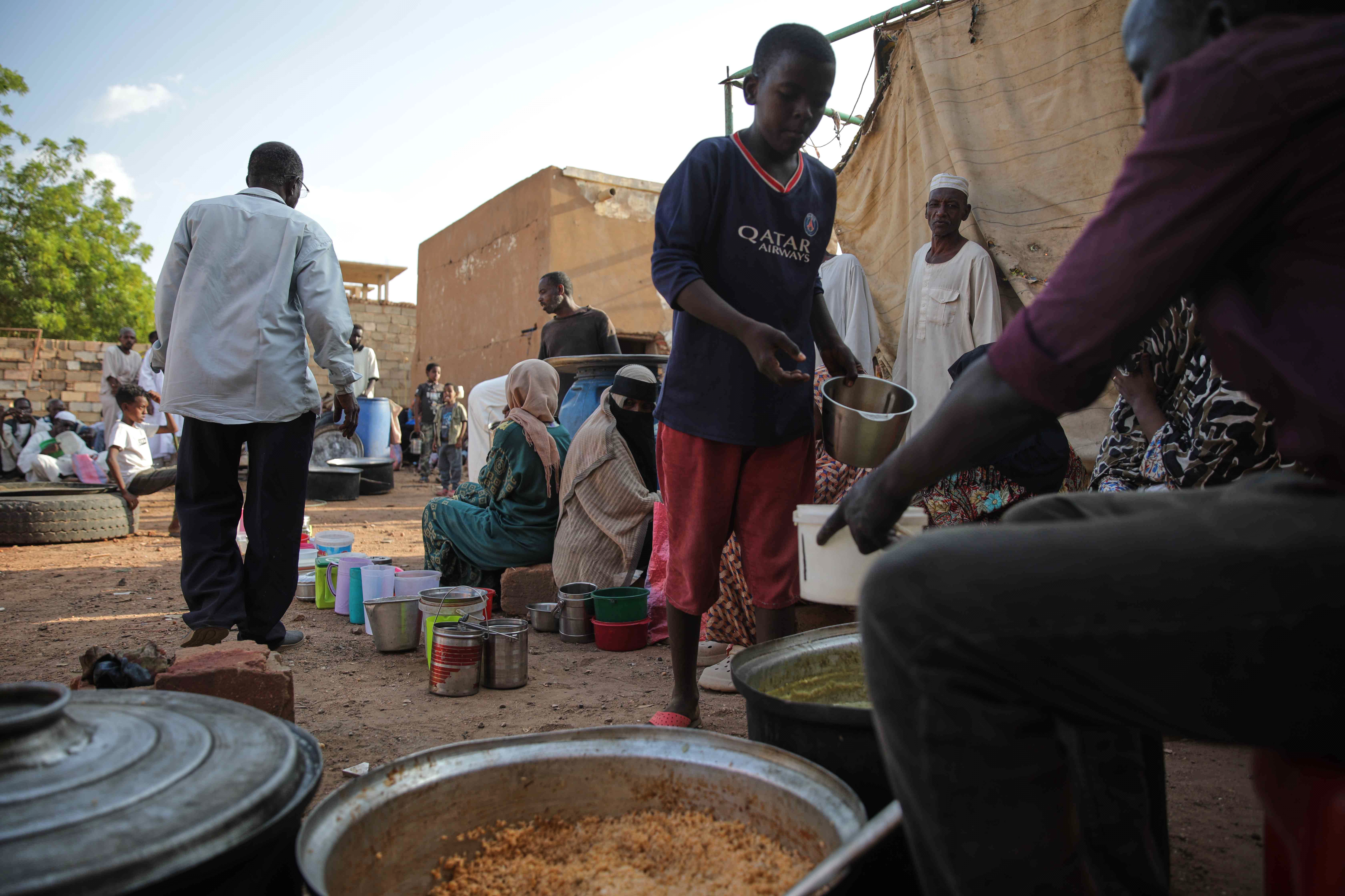 A boy holds a food container while waiting to receive donated food at a community kitchen in Khartoum, Sudan, Wednesday, Sept. 23, 2026. (AP Photo/Marwan Ali)
