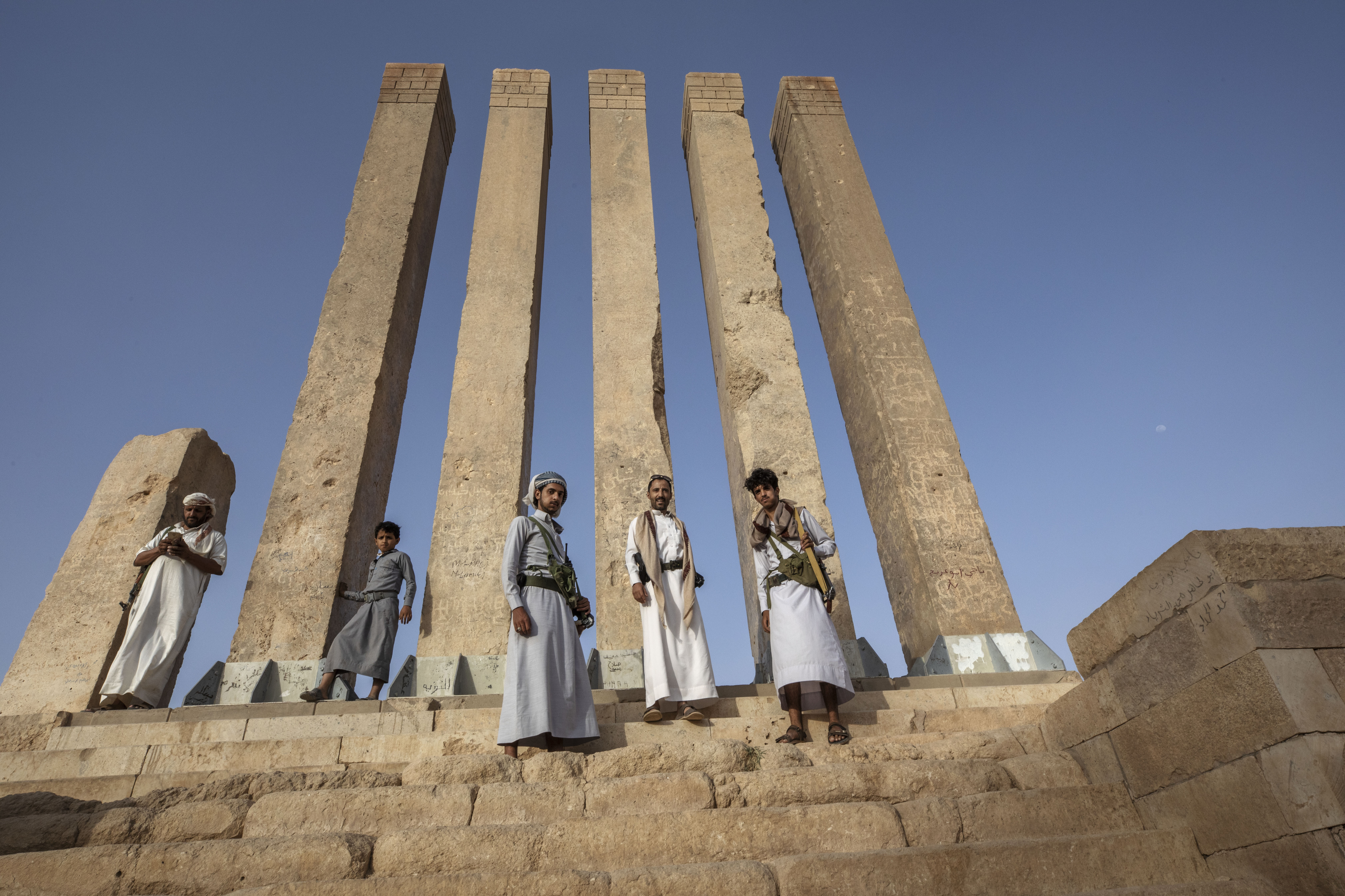 FILE - Armed men allied to Yemen's internationally recognized government pose for a photograph at Awwam Temple, also known as the Mahram Bilqis, in Marib, Yemen, on June 21, 2021. UNESCO on Wednesday Jan. 25, 2023 added one of Yemen's ancient kingdoms and a Lebanese modernist concrete fair park to its list of World Heritage sites in danger, the latest entries from The Middle East. (AP Photo/Nariman El-Mofty, File)
