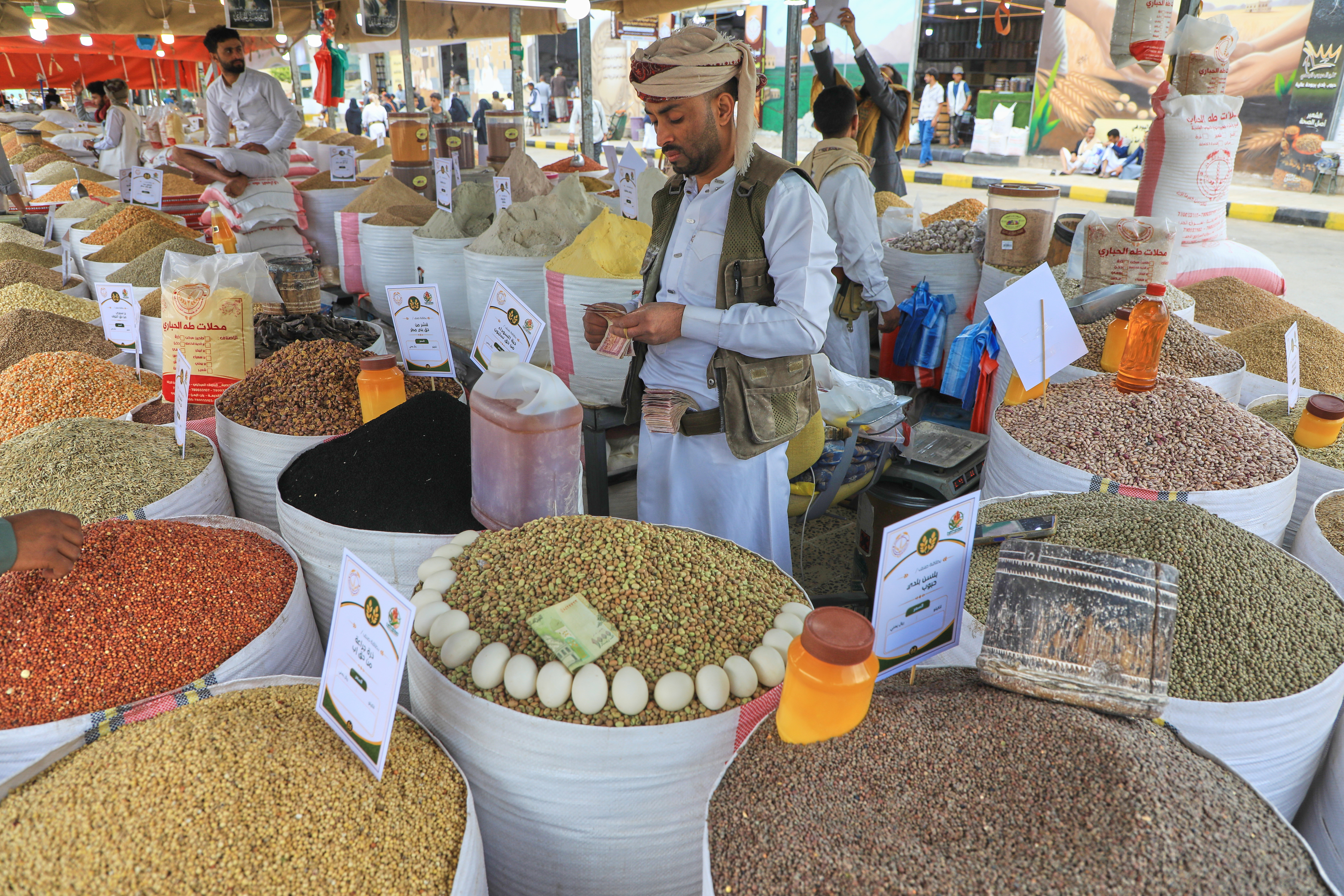 A vendor counts money at his booth during an agriculture festival in Sanaa, Yemen, Wednesday, Sept. 23, 2026. (AP Photo/Osamah Abdulrahman)