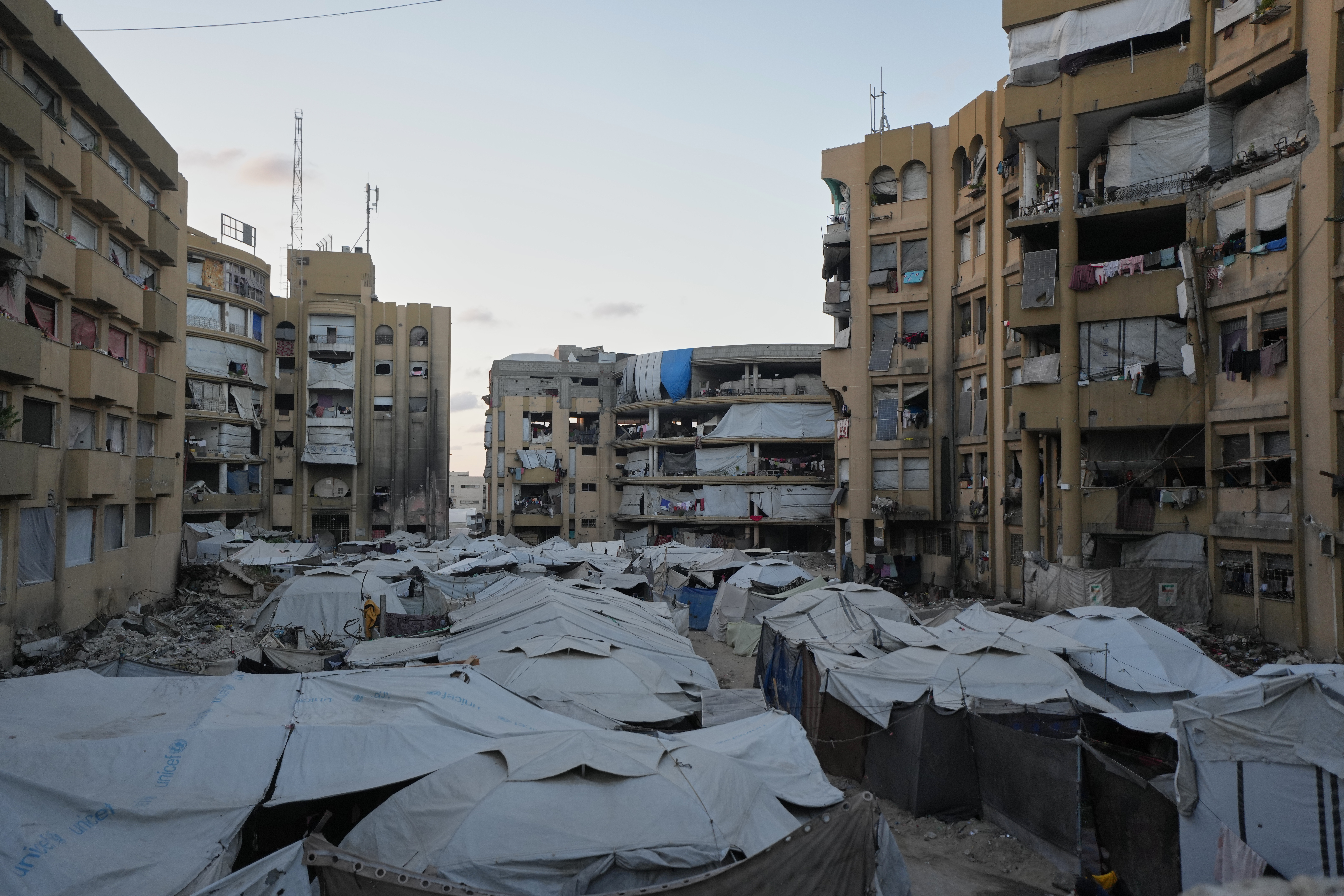 Tents sheltering displaced Palestinians stand amid damaged buildings in Gaza City, Thursday, Oct. 8, 2026. (AP Photo/Jehad Alshrafi)