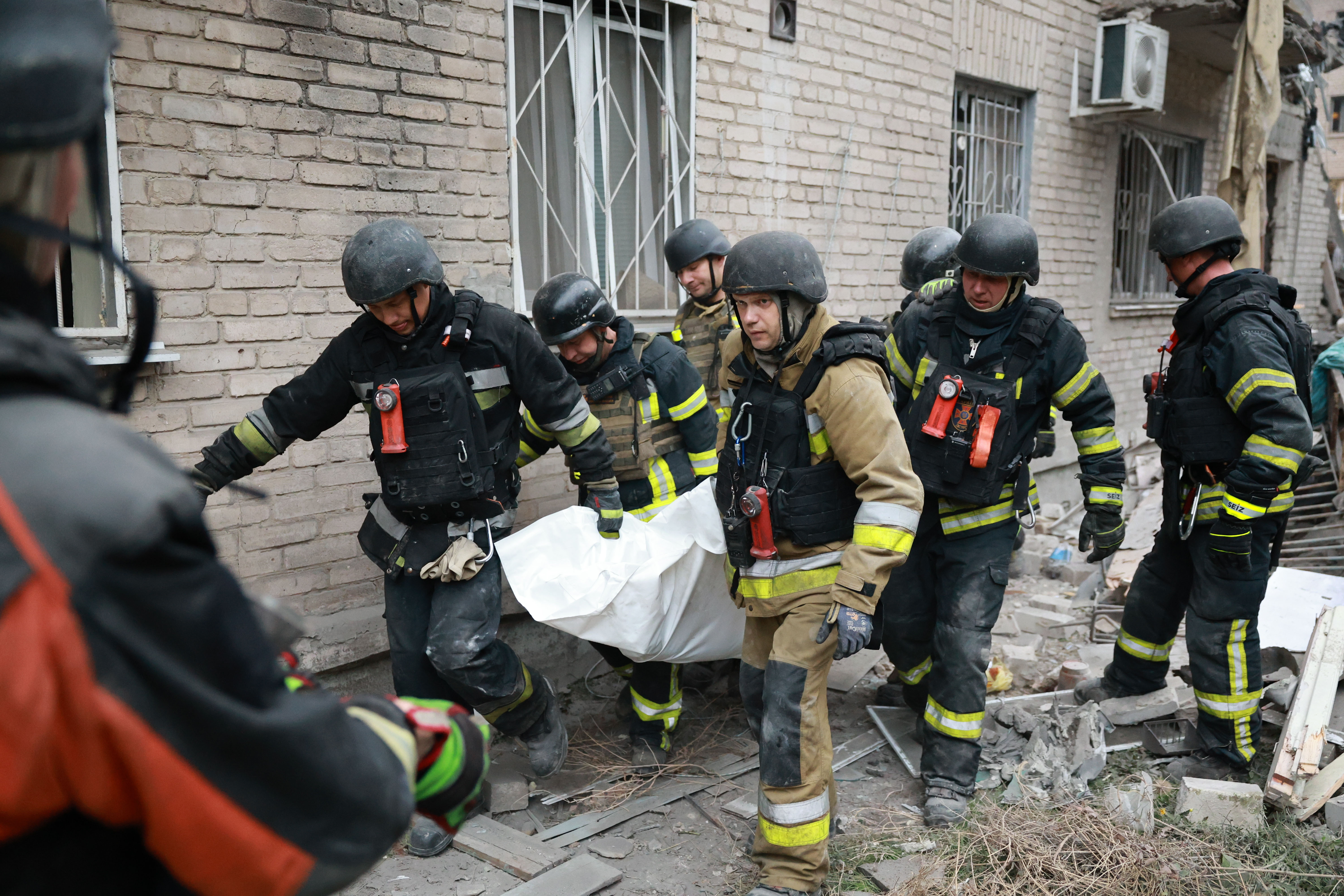 Rescue workers carry a body.