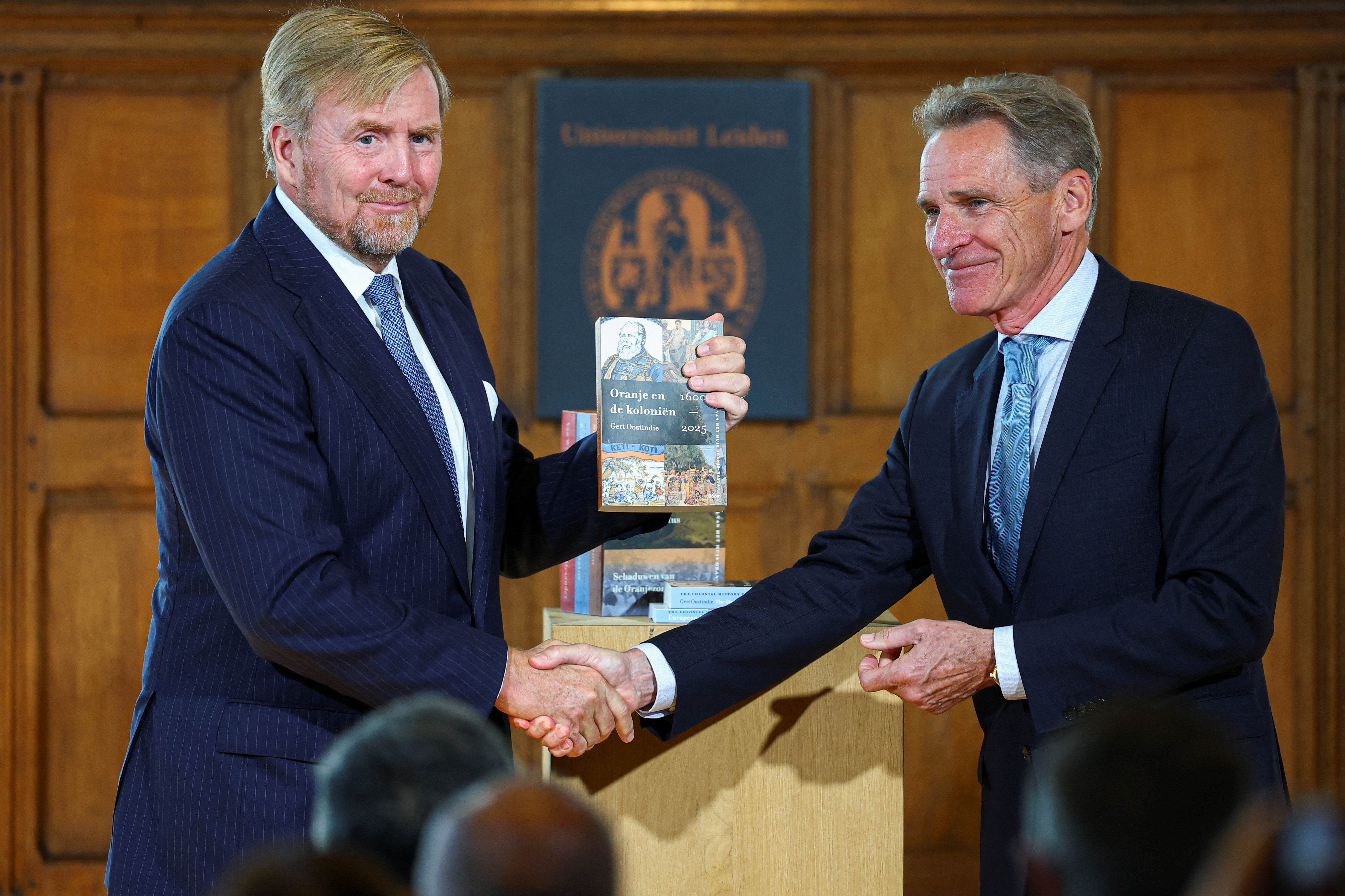 Dutch historian Gert Oostindie, right, presents a volume of an independent study into the role of the House of Orange-Nassau in Dutch colonial history to King Willem-Alexander in Leiden, the Netherlands, on October 2, 2026