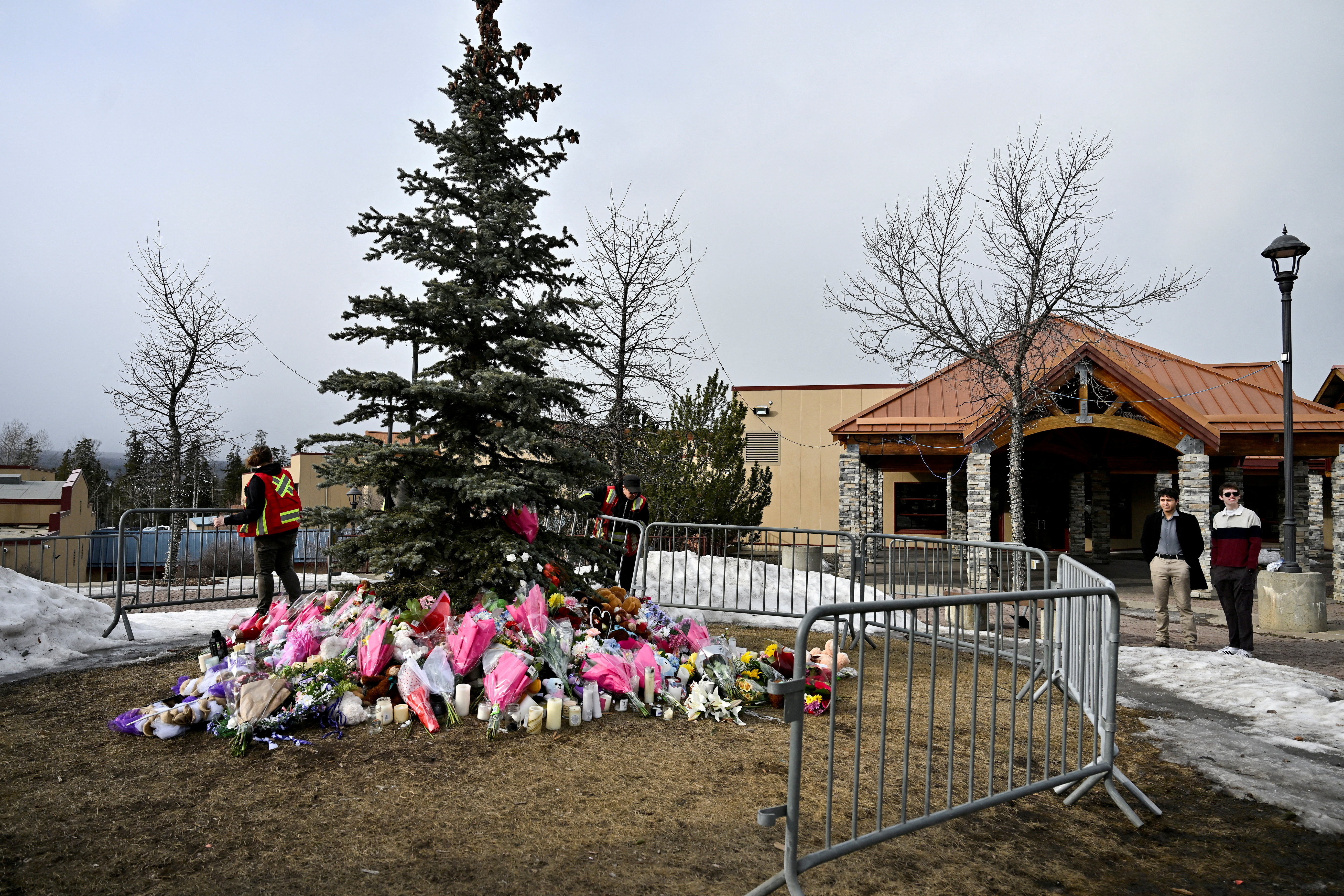 FILE PHOTO: Workers install a fence around a makeshift memorial for the victims two days after a deadly mass shooting took place at a school in the town of Tumbler Ridge, British Columbia, Canada, February 12, 2026. REUTERS/Jennifer Gauthier/File Photo
