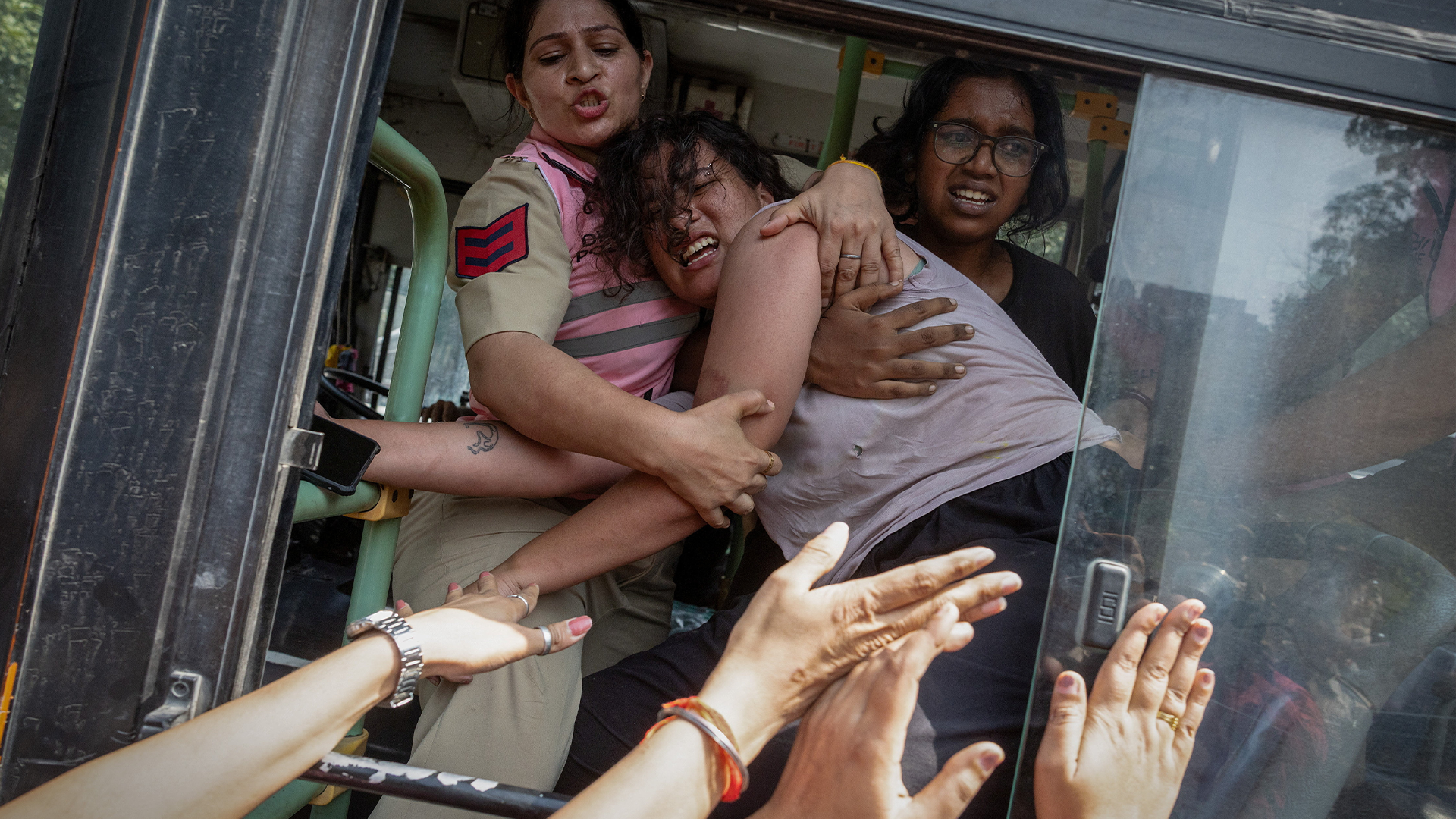 Policewomen try to stop a detained protestor to escape from a bus during a protest by the Cockroach Janta Party (CJP) seeking the resignation of India's Chief Election Commissioner Gyanesh Kumar, near the protest site in New Delhi, India, October 10, 2026. REUTERS